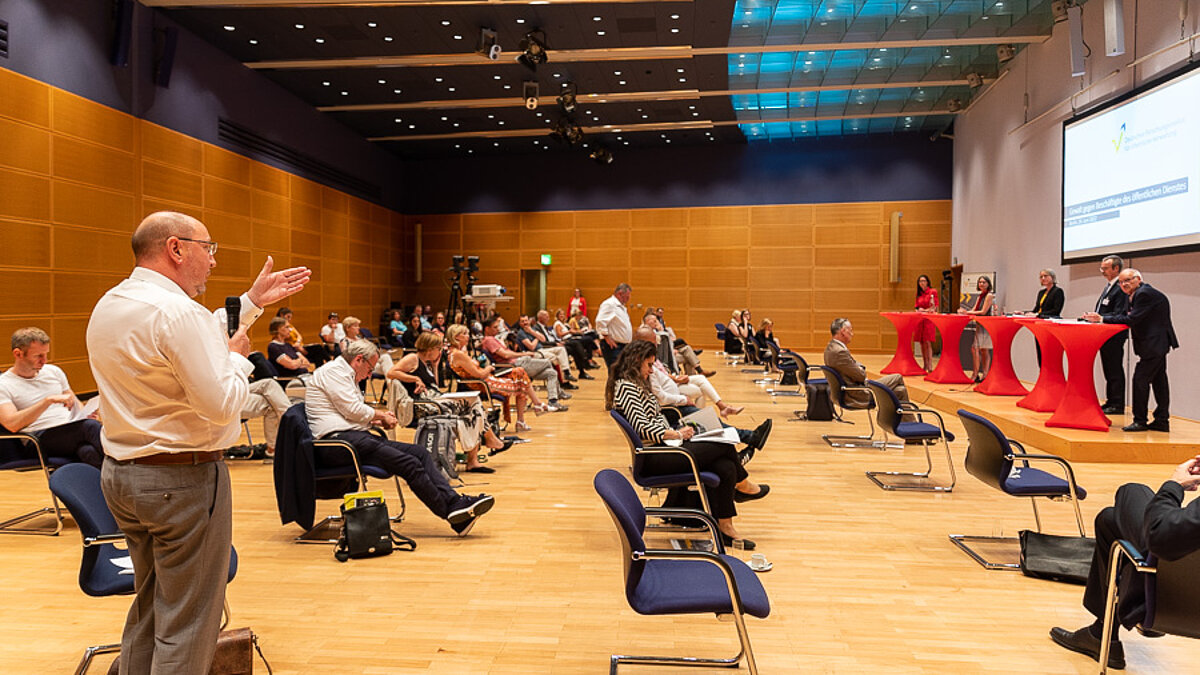 Audience, a man stands