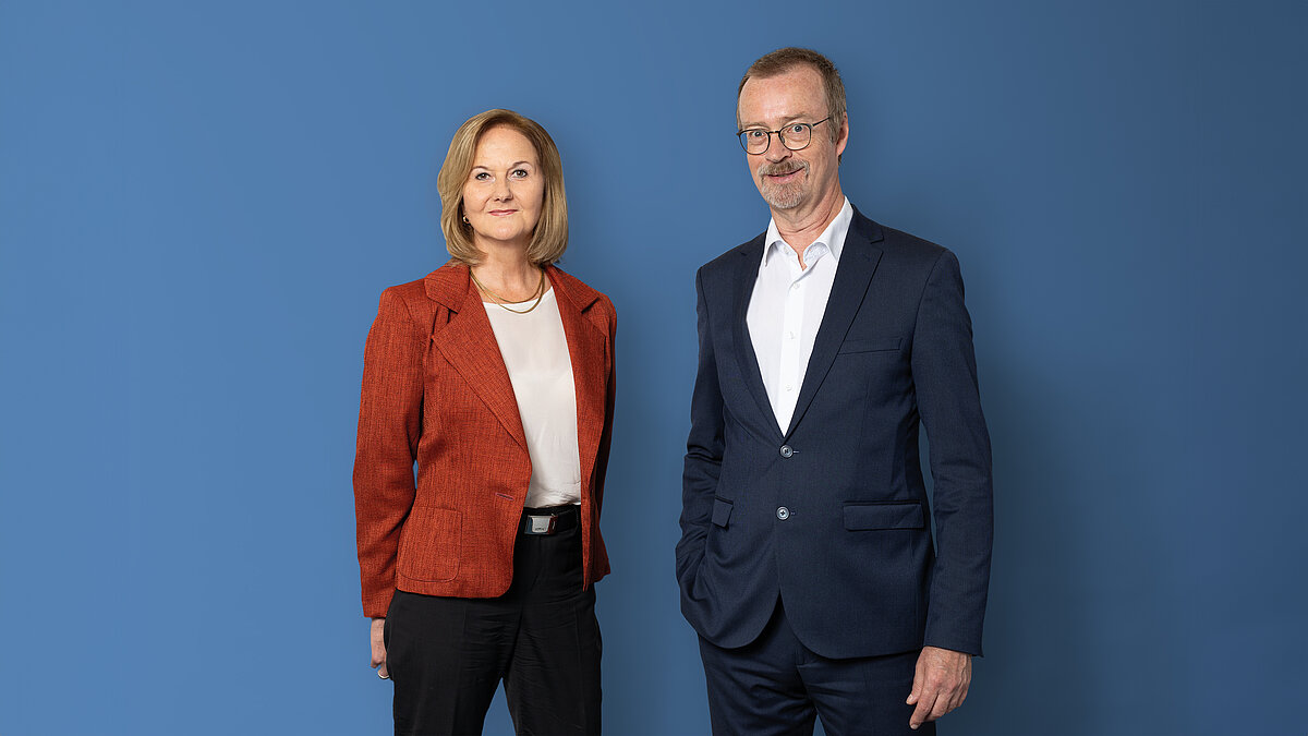 Halbkörper-Porträt von Frau Dr. Keil, links, und Prof. Dr. Ziekow, rechts, vor blauem Hintergrund.