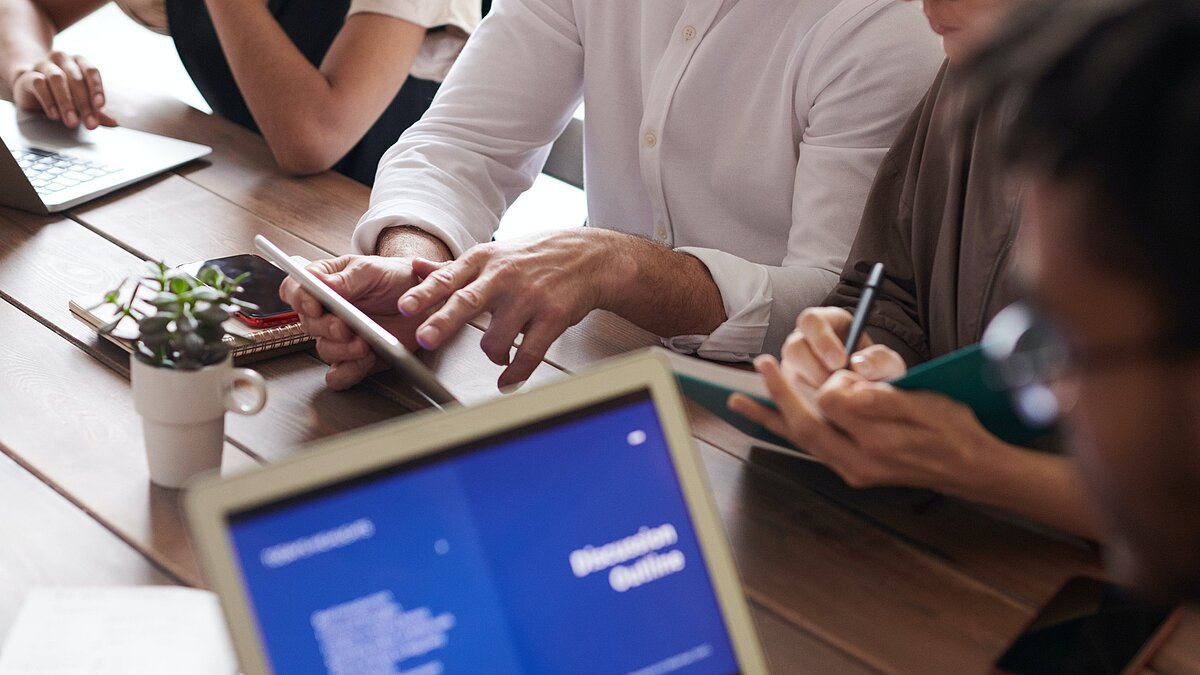 Arbeitende Personen am Tisch mit Laptop