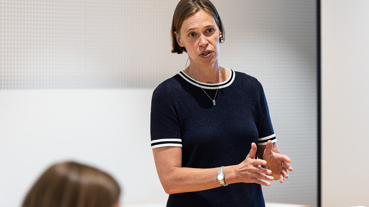 Woman standing in front of an audience.