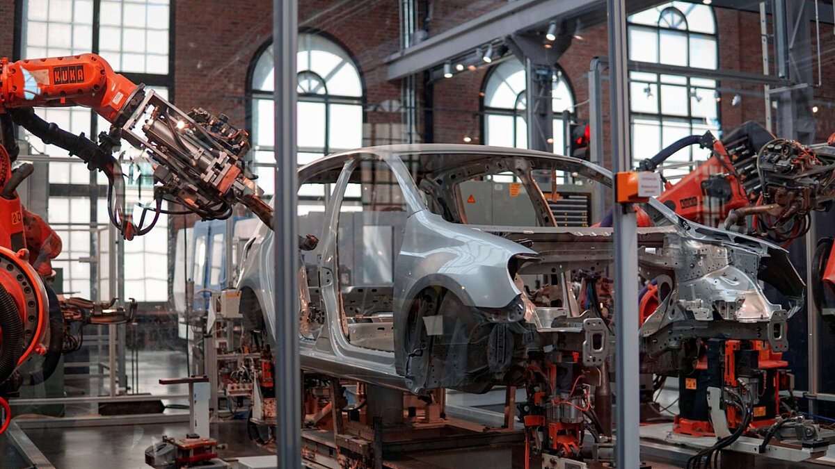 Graues Fahrzeug, das in der Fabrik mit Robotermaschinen repariert wird.