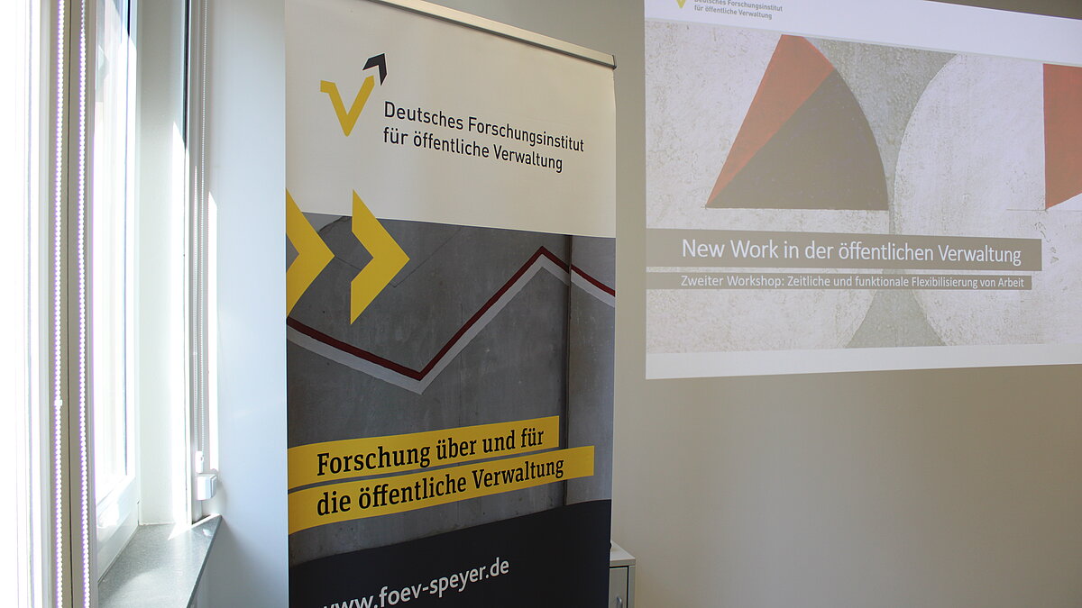 Ein Banner des FÖV und eine Präsentation sind im Workshop-Raum zu sehen.